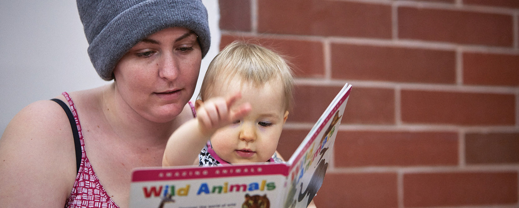 Mother and infant read a book together.